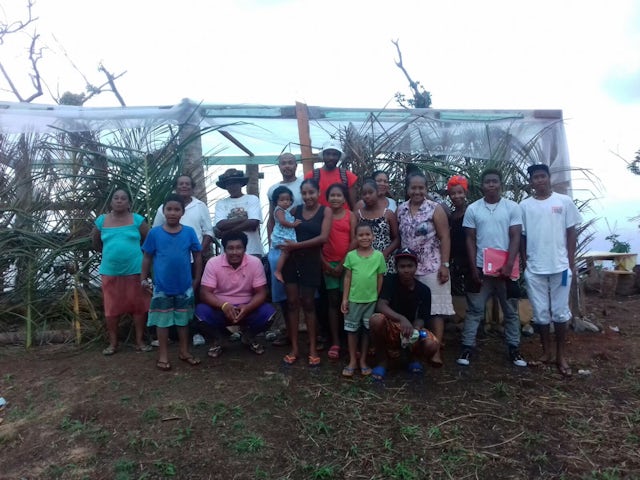 Friends and neighbors gather in front of a greenhouse they constructed together. The community in this part of the remote Kalinago territory has begun to hold classes for children and young adolescents on the site, as well as prayer gatherings open to all.