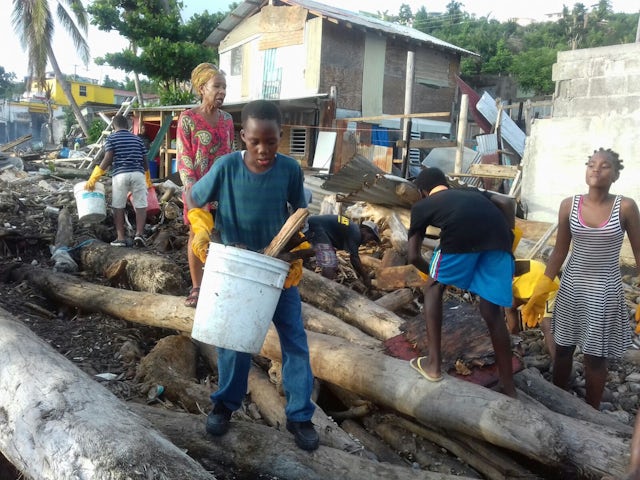 Neighbors in the Newtown neighborhood of Roseau help clear the bay of debris following the destruction left by the hurricane.